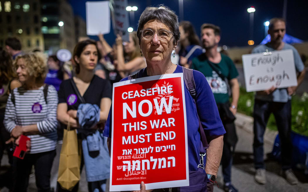Left-wing protestors hold a sign that says "ceasefire now, this war must end" at a demonstration for a ceasefire and hostage deal outside the Knesset in Jerusalem on March 31, 2024. (Photo by Emily Glick / Middle East Images / Middle East Images via AFP)