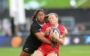 Claire Gallagher of Canada is tackled by Ayesha Leti-I'iga of the Black Ferns.