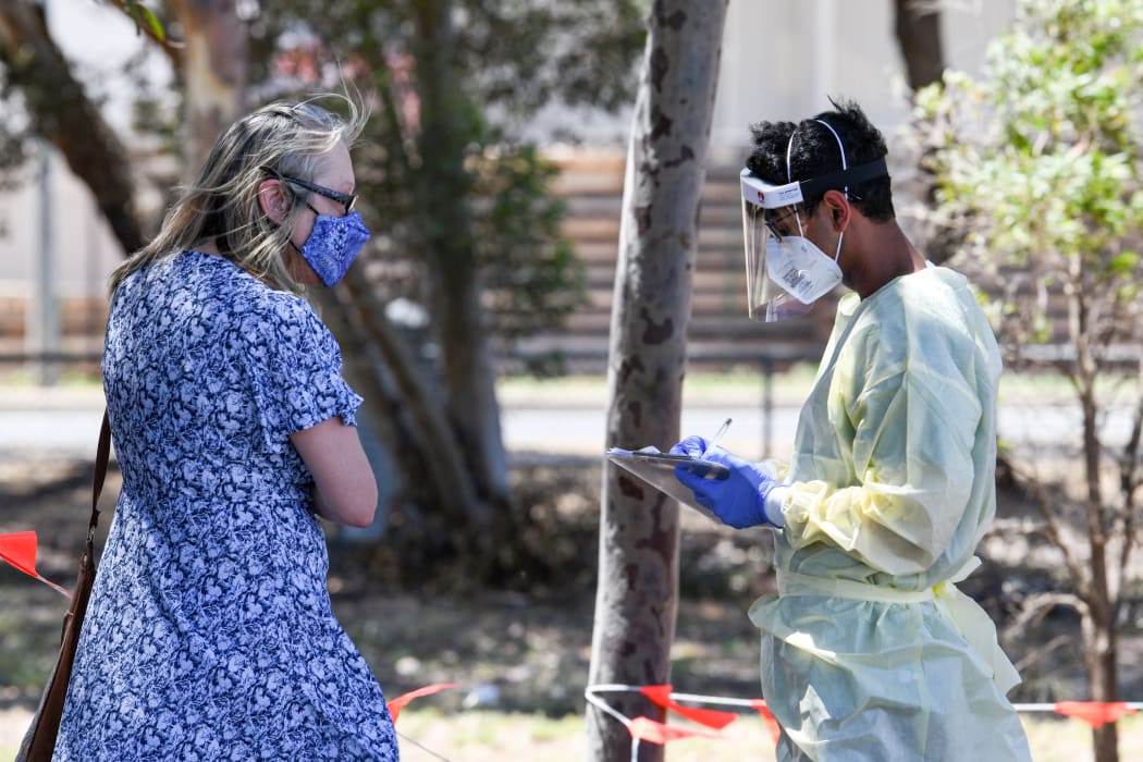 Medical staff talk to people at a walk in station at Parafield Airport in Adelaide during day one of total lockdown across the state to fight Covid-19.