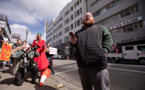 PPTA acting president Chris Abercrombie talks at a protest down Wellington's CBD to Grant Robertson's office.