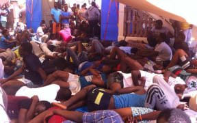 People rest in the shade on the Responder after being rescued.