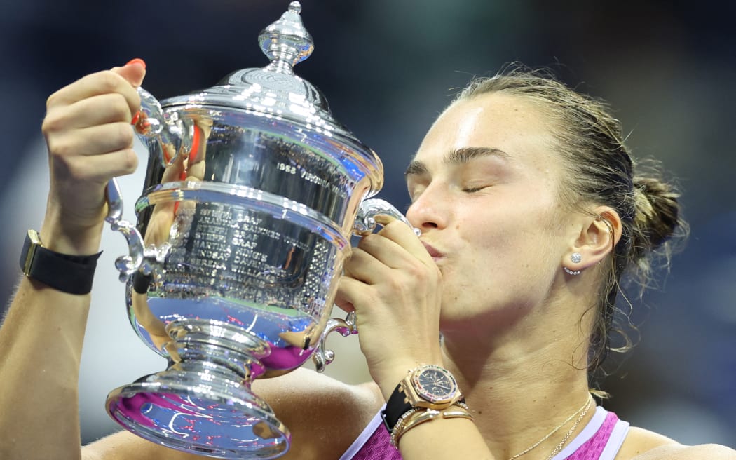 Belarus's Aryna Sabalenka kisses the trophy after defeating USA's Jessica Pegula during their women's final match.