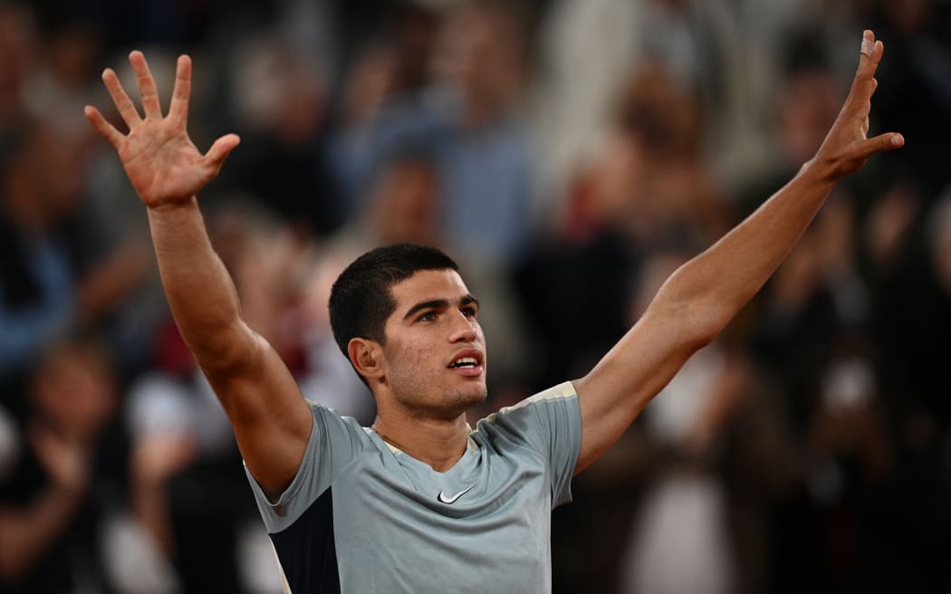 Spain's Carlos Alcaraz celebrates after victory over US' Sebastian Korda in their men's singles match on day six of the Roland-Garros Open tennis tournament at the Court Philippe-Chatrier in Paris on May 27, 2022. (Photo by Christophe ARCHAMBAULT / AFP)