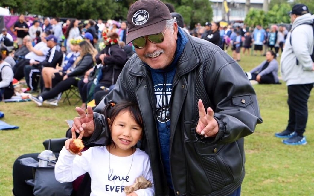 Joseph Henry with his granddaughter eagerly awaiting for his other grandkids to perform on stage - day 2 Polyfest 2021.