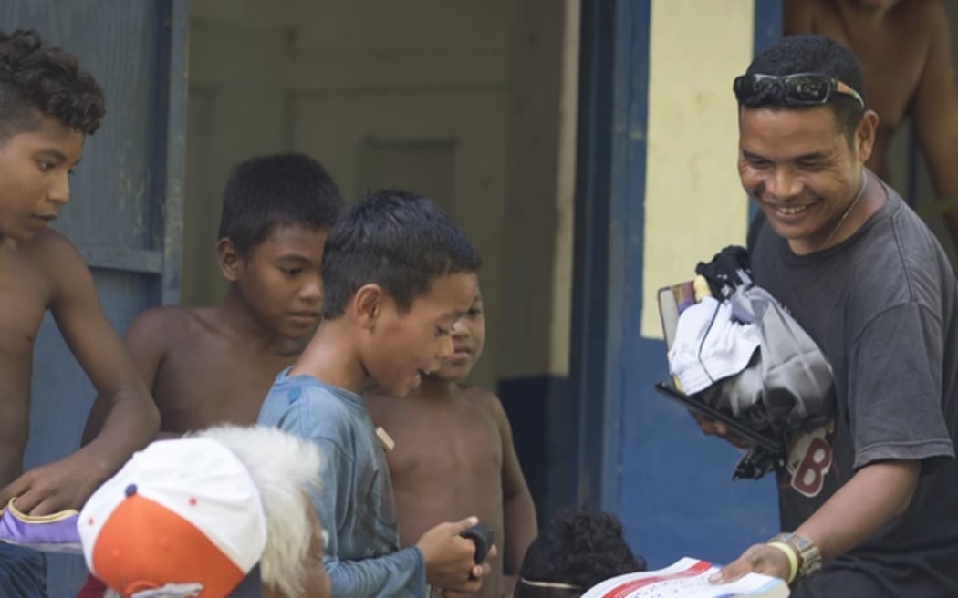 Children inspect supplies dropped as part of Operation Christmas Drop.