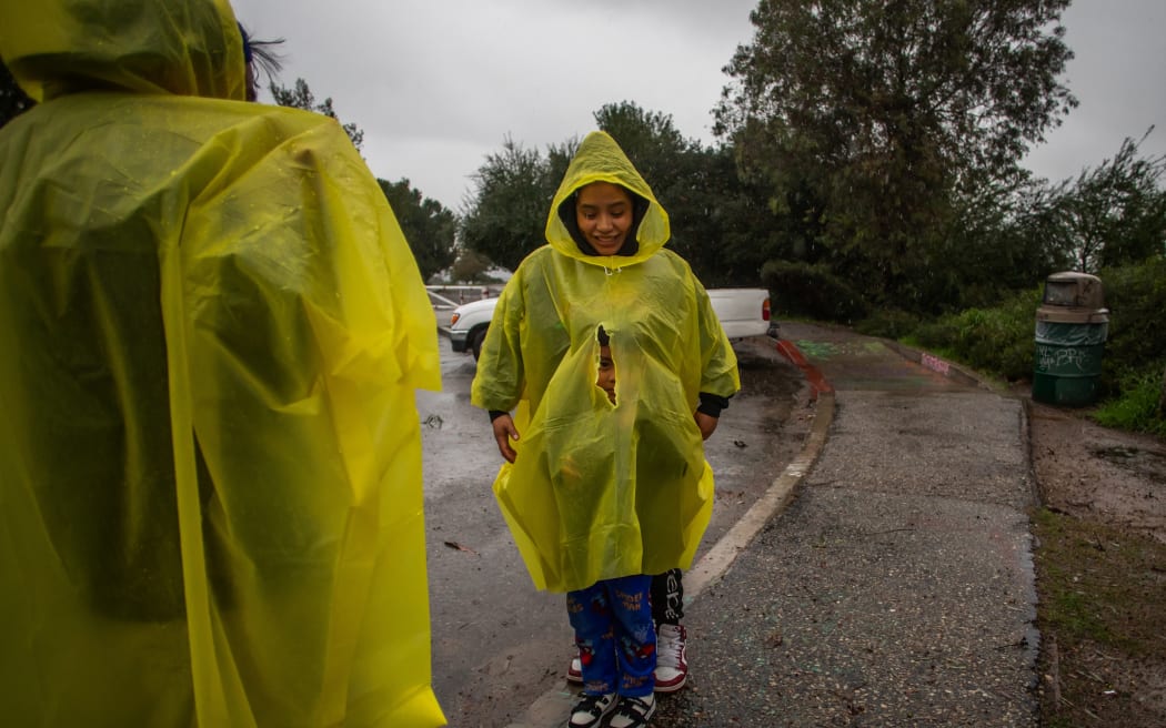 A family walks at Elysian Park in the rain on December 24, 2025 in Los Angeles, California. A major winter storm rolled into California on December 23, forcing hundreds of evacuations in burn areas while threatening flooding and travel delays through Christmas for much of the state, officials said.
A "strong atmospheric river brings heavy rain, snow, and wind to California through Friday," the National Weather Service said in a statement on December 23, warning anyone in northern, central and southern parts of the state to "exercise extreme caution." (Photo by Apu GOMES / AFP)