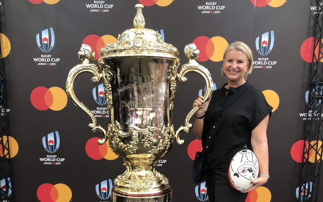 Kate Lawless posing with an enlarged replica of the Webb Ellis trophy.