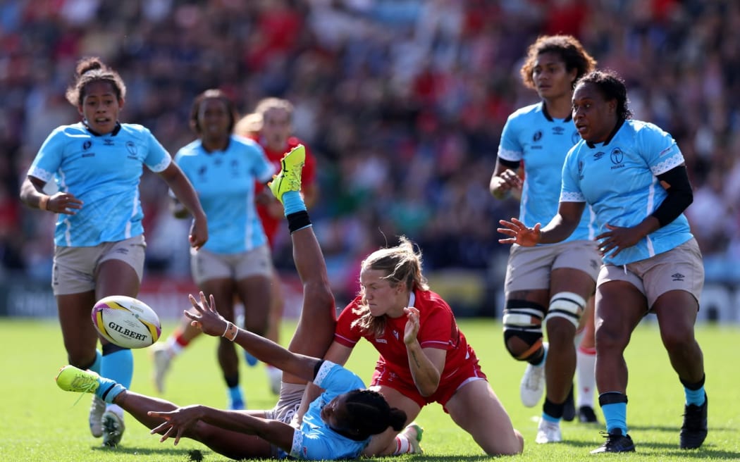 EXETER, ENGLAND - SEPTEMBER 06: Verenaisi Ditavutu of Fiji offloads the ball whilst on the floor after being tackled by Carys Cox of Wales during the Women's Rugby World Cup 2025 Pool B match between Wales and Fiji at Sandy Park on September 06, 2025 in Exeter, England. (Photo by Morgan Harlow - World Rugby/World Rugby via Getty Images)