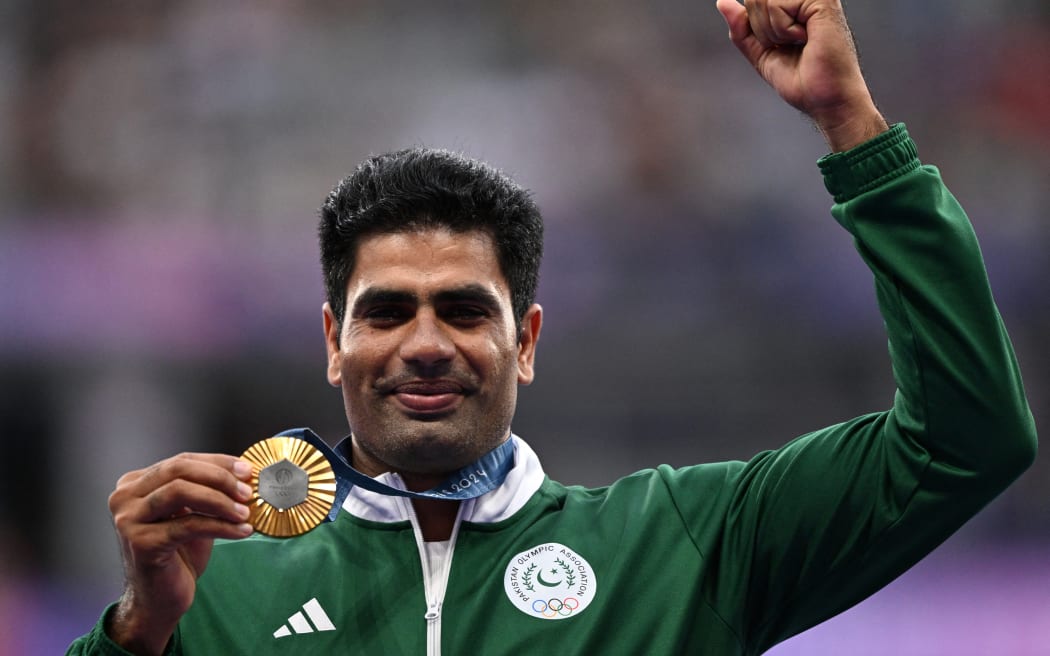 Gold medallist Pakistan's Arshad Nadeem celebrates on the podium during the victory ceremony for the men's javelin throw athletics event during the Paris 2024 Olympic Games at Stade de France in Saint-Denis, north of Paris, on August 9, 2024. (Photo by Kirill KUDRYAVTSEV / AFP)