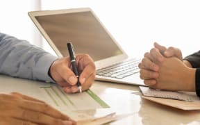 someone filling in a deposit slip in a bank