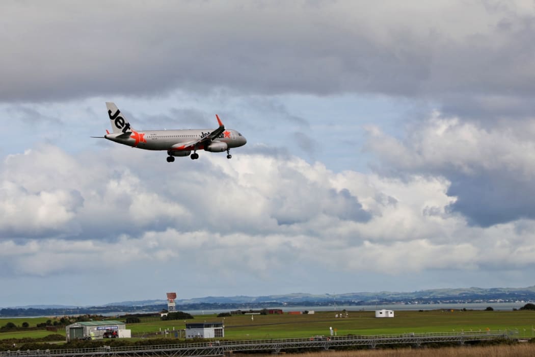 Jetstar plane flies in to Auckland Airport.