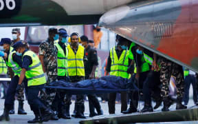 Nepalese soliders carry the body of a victim killed in a Tara Air plane crash as it arrives in Kathmandu, Nepal, 30 May, 2022.