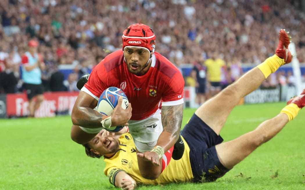 Tonga's inside centre Pita Ahki dives across the line to score a try during the France 2023 Rugby World Cup Pool B match between Tonga and Romania at the Stade Pierre-Mauroy in Villeneuve-d'Ascq, near Lille, northern France on October 8, 2023.