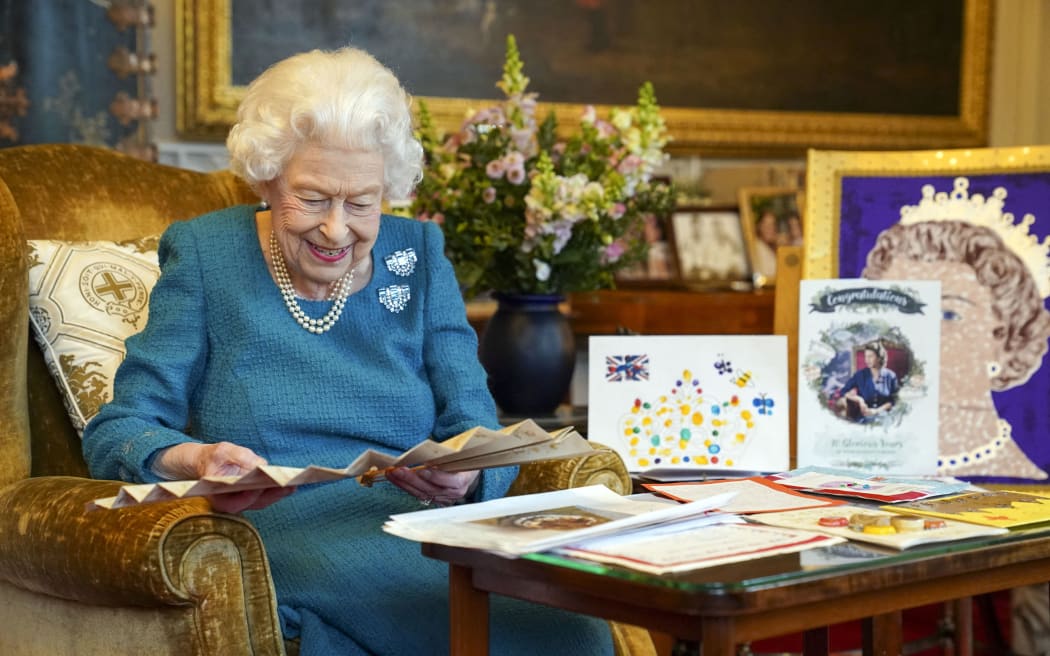 Queen Elizabeth II looking at Queen Victoria's Autograph fan, alongside a display of memorabilia from her Golden and Platinum Jubilees, in the Oak Room at Windsor Castle, west of London in January 2022.