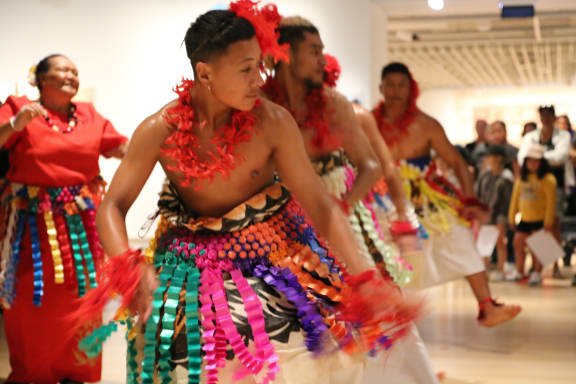 Tongan dancers of the Akomai Heritage Group in costumes made from ngatu, In the background is Melesiu Katoa one of the most experienced ngatu makers in the group.