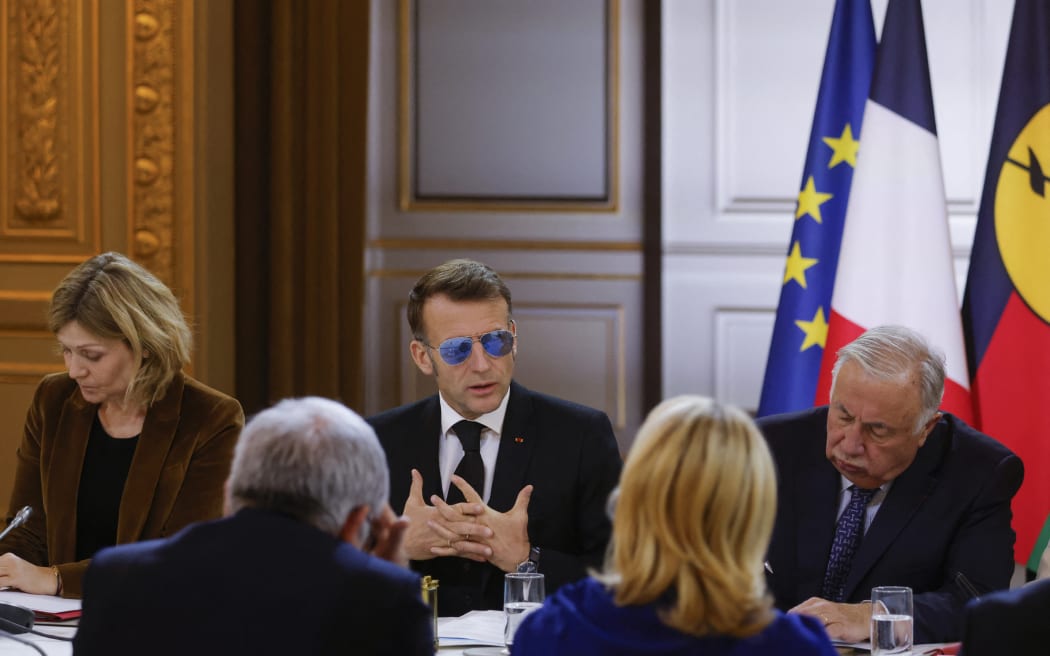French President Emmanuel Macron, flanked by the National Assembly's President Yael Braun-Pivet (L) and the Senate's President Gerard Larcher (R), speaks during a meeting on the institutional future of New Caledonia at the Elysee Palace in Paris on January 16, 2026. Macron opened a new round of discussions on the institutional future of New Caledonia, stating his desire to move forward “without forcing the issue but without paralysis,” despite the absence of the main independence movement. (Photo by Yoan VALAT / POOL / AFP)