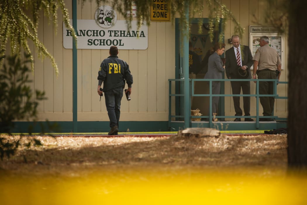 FBI agents are seen behind yellow crime scene tape outside Rancho Tehama Elementary School.