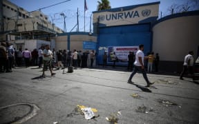 Palestinian protesters throw eggs at the entrance of the Gaza City headquarters of the United Nations Relief and Works Agency for Palestine Refugees (UNRWA) on August 7, 2023, during a demonstration demanding that their homes which were destroyed in the 2014 conflict with Israel be rebuilt.  (Photo by Majdi Fathi/NurPhoto) (Photo by MAJDI FATHI / NurPhoto / NurPhoto via AFP)