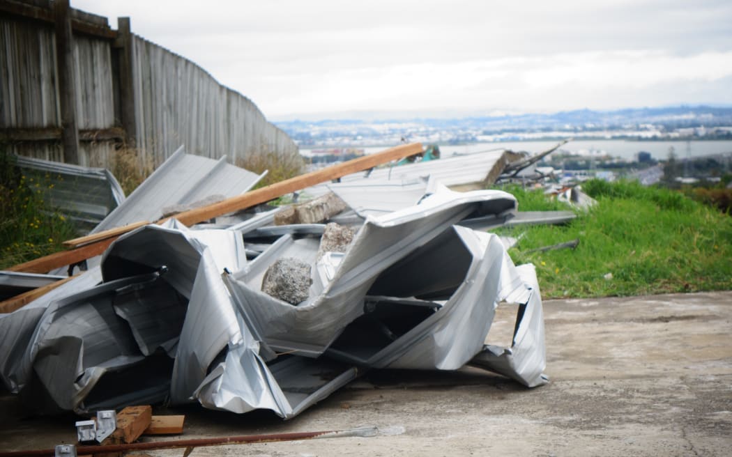 The roof of an unoccupied home in the Auckland suburb of Hillsborough came off in high winds and scattered debris down the road.
