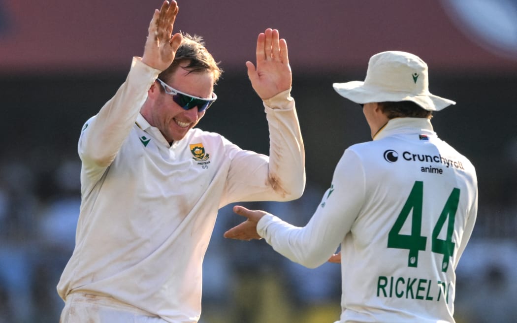 South Africa's Simon Harmer (L) celebrates with teammate Ryan Rickelton.