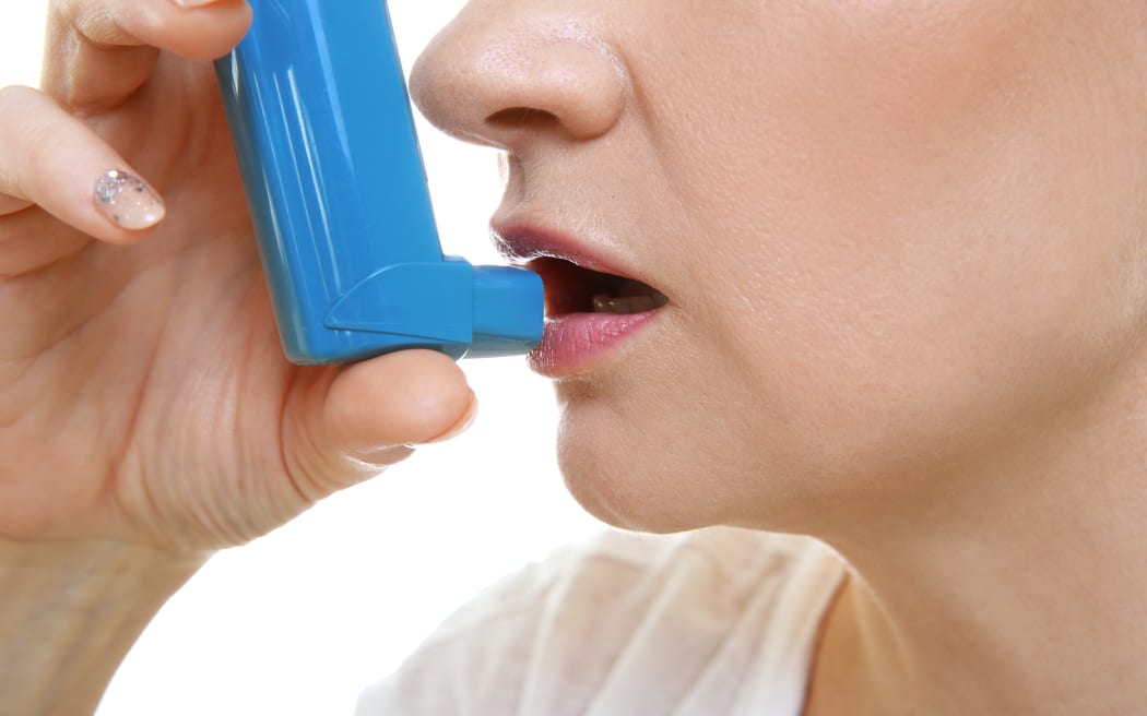 Adult woman using inhaler