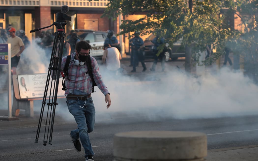 A member of the media runs through tear gas during a protest on May 28, 2020 in St. Paul, Minnesota.