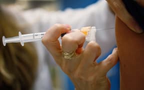 University of Miami pediatrician Judith L. Schaechter gives an HPV vaccination to a 13-year-old girl in her office at the Miller School of Medicine on 21 September 2011 in Miami, Florida.