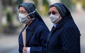 Nuns wearing face masks stand inside the closed Monumental Cemetery of Bergamo, Lombardy during the country's lockdown.