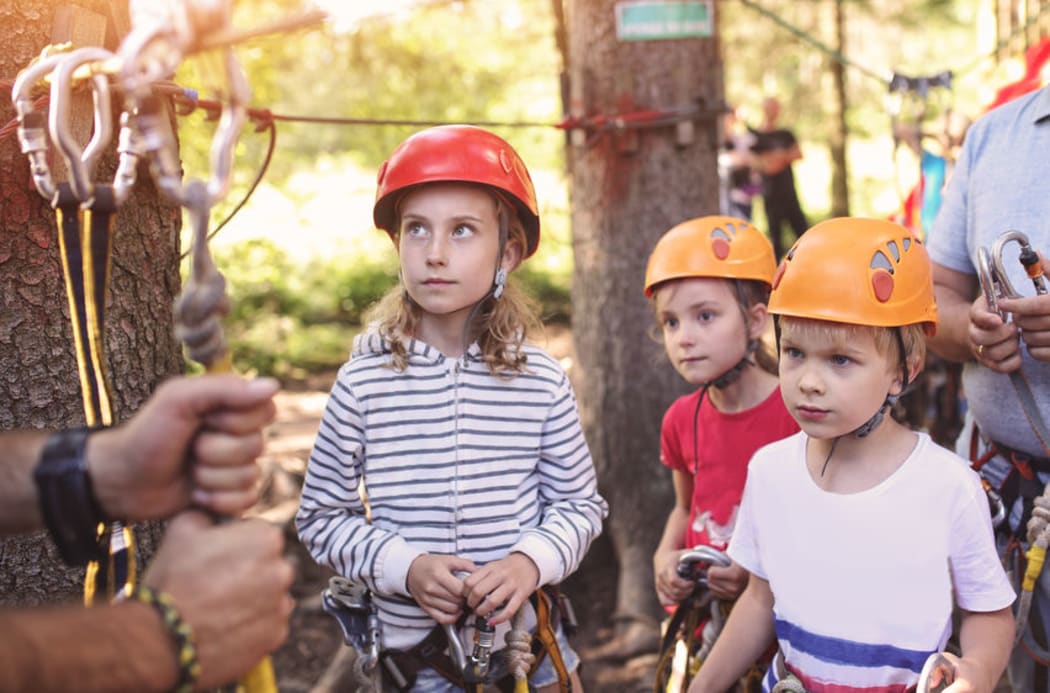 A Photo of a group of girls learning to climb on an adventure course