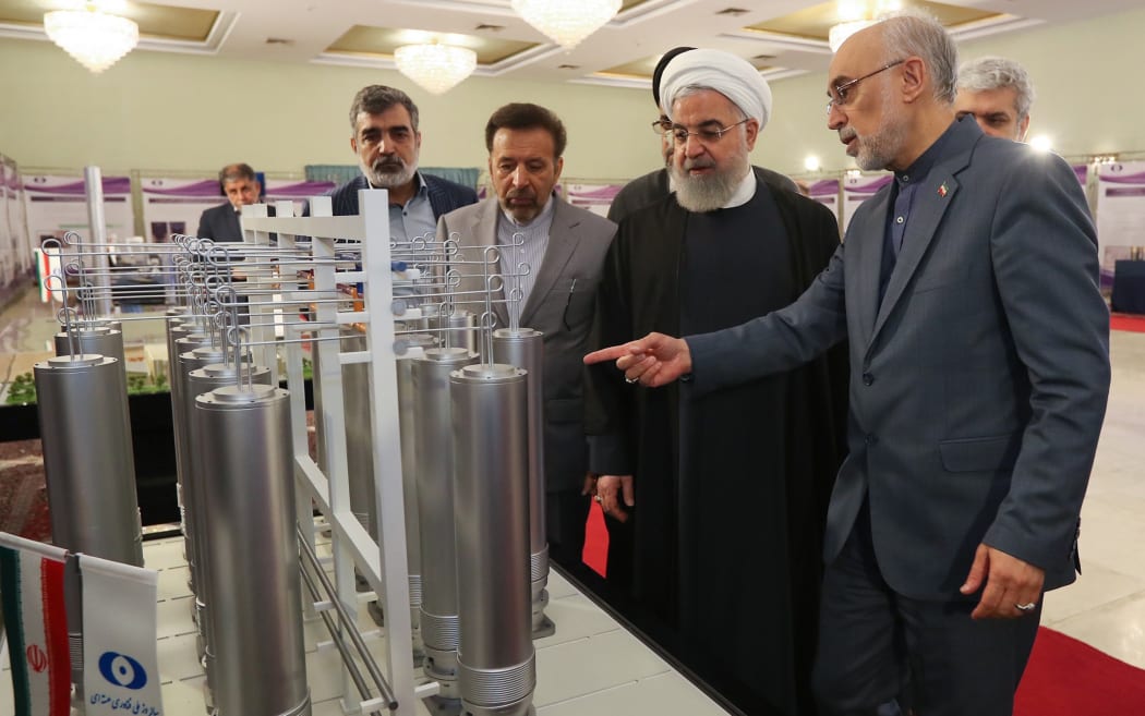 Handout picture by the Iranian presidential office shows, Iranian President Hassan Rouhani (second left) with head of Iran's nuclear technology organisation Ali Akbar Salehi (right) during the "nuclear technology day" in Tehran in 2019.