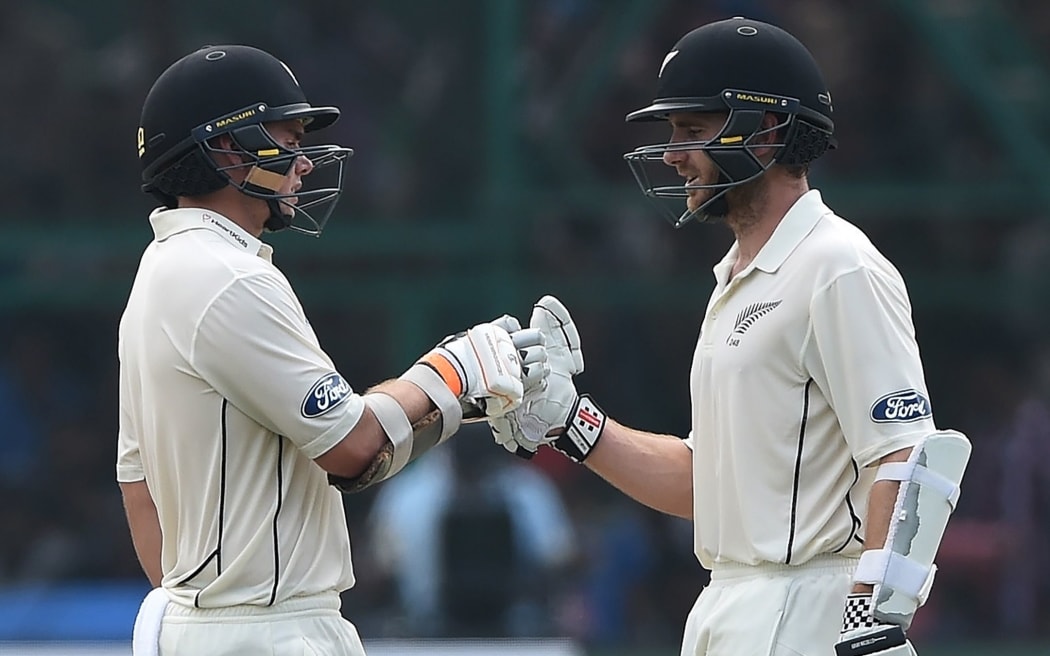 New Zealand's captain Kane Williamson (R) congratulates Tom Latham after his half century during the second day of the first Test match between India and New Zealand at Green Park Stadium in Kanpur on September 23, 2016.