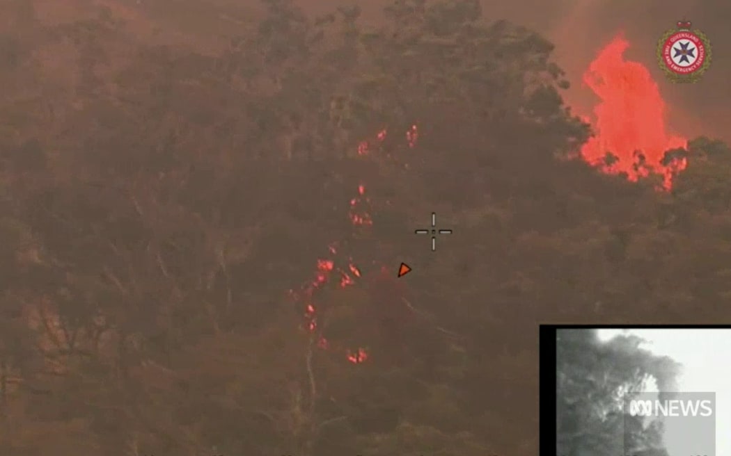 Video from a QFES chopper shows the fire burning through bushland in Wallangarra.