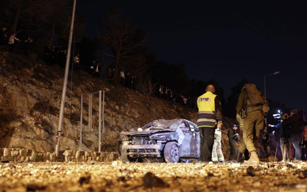 Israel security forces inspect a damaged car after a missile struck a road in Jerusalem on March 1, 2026. The United States and Israel launched strikes against Iran on February 28, killing Iran's supreme leader and top military leaders, prompting authorities to retaliate with strikes on Israel and US bases across the Gulf. (Photo by HAZEM BADER / AFP)