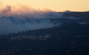 An aerial image shows fire and smoke behind the Getty Center Museum from wildfires, including the Palisades Fire, at sunset over Los Angeles, California, on January 8, 2025. - At least five people are now known to have died in wildfires raging around Los Angeles, with more deaths feared, law enforcement said January 8, as terrifying blazes leveled whole streets, torching cars and houses in minutes.
More than 1,000 buildings have burned in multiple wildfires that have erupted around America's second biggest city, forcing tens of thousands of people from their homes. (Photo by Patrick T. Fallon / AFP)