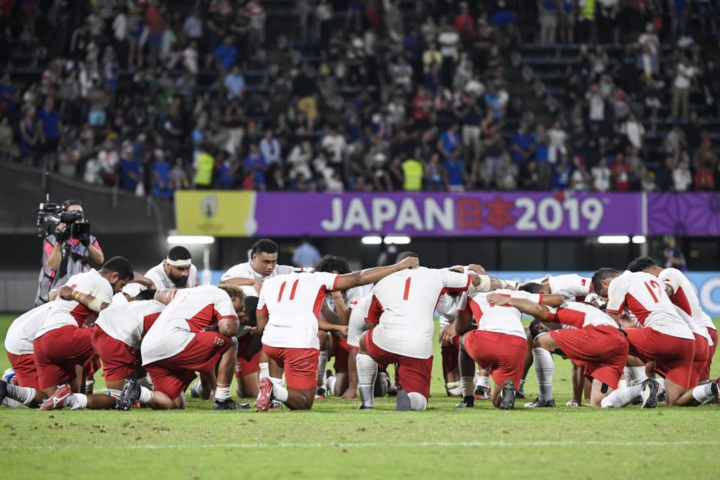 Tonga's players pray after their dramatic defeat by France.