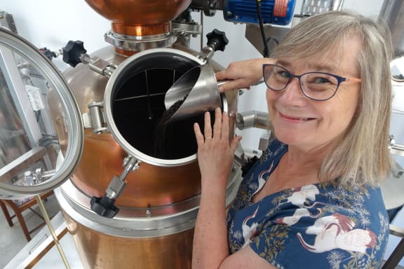 Jo James loads a still with juniper berries.