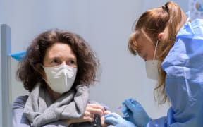 19 March 2021, Berlin: Berlin doctor Natascha Kempkes vaccinates Beatrix Mengen in Terminal C of the former Tegel Airport at the Corona Vaccination Centre with Astrazeneca's Corona vaccine.