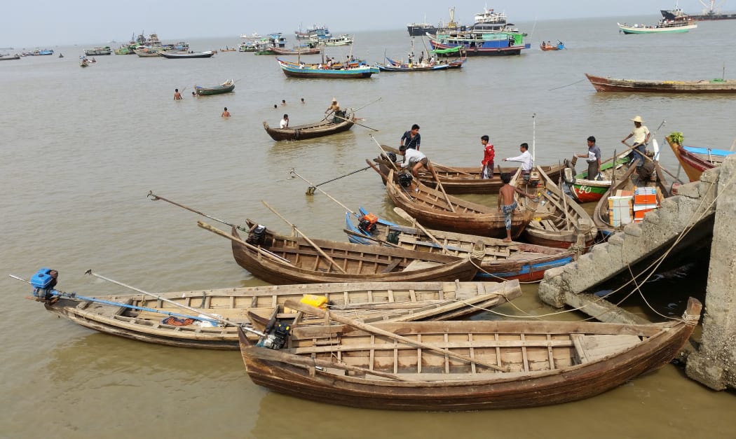 Local craft tie up to concrete steps with men also in the calm but dirty water