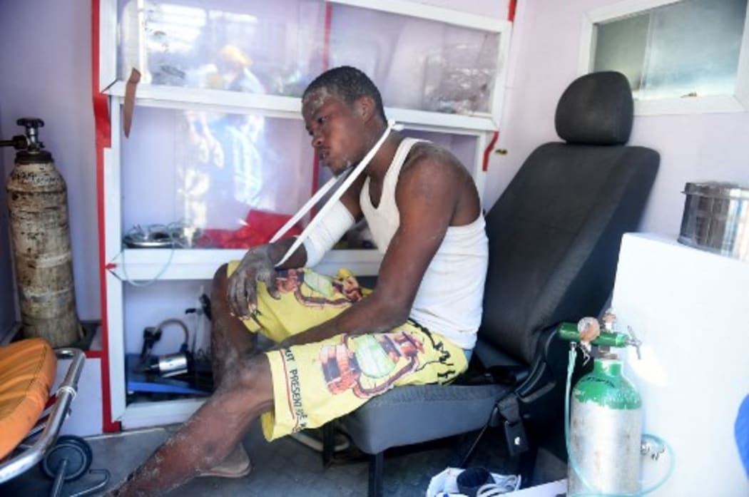 An injured worker sits in an ambulance after being pulled out from the rubble