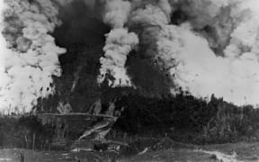 The start of a 30,000 acre fire, lit to clear the land of bush, Pukatora Station, East Coast, taken in the early 1900s.