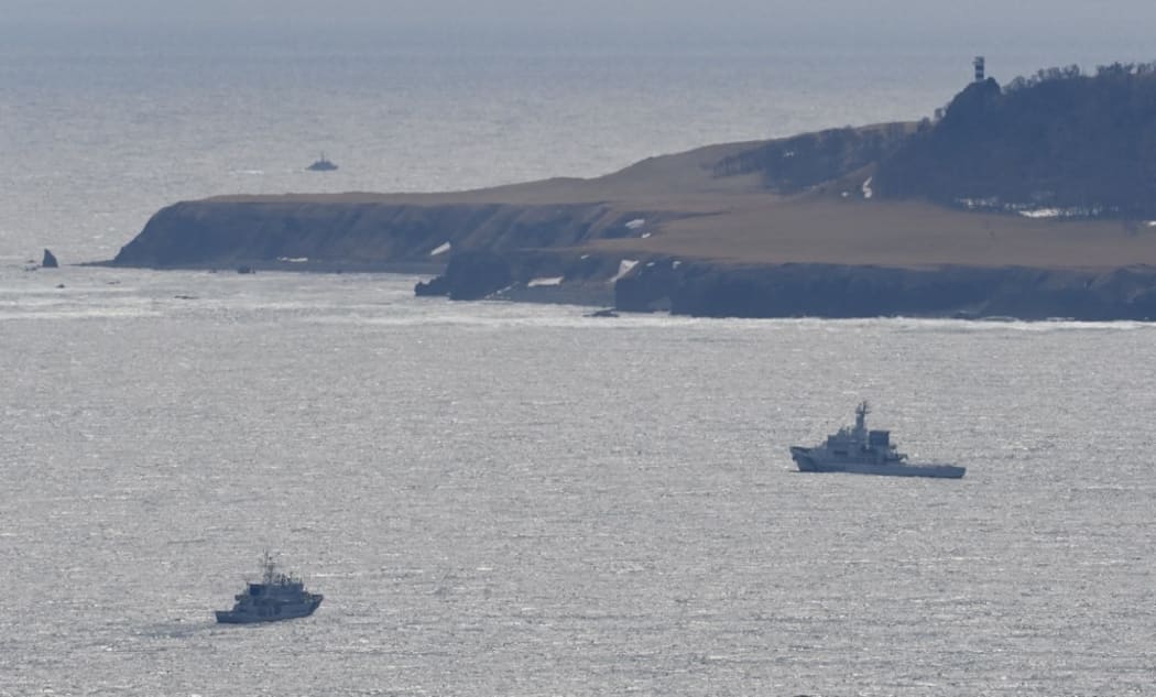 An aerial photo shows a search in Shari Town, Hokkaido Prefecture on April 24, 2022. The Japan Coast Guard said on the same day that it found more than ten people on the sea and on rocks around the tip of Cape Shiretoko, where a sightseeing boat with 26 people aboard went missing.