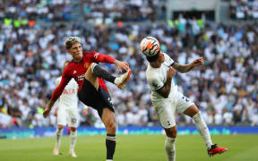 Pedro Porro of Tottenham Hotspur (R) heads the ball past Alejandro Garnacho of Manchester United.