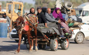 Palestinian families are fleeing the city on the coastal road leading to Rafah from the southern outskirts of Khan Yunis, in the southern Gaza Strip, amid ongoing battles between Israel and the Palestinian militant group Hamas, in Khan Yunis, Gaza Strip, on January 22, 2024. (Photo by Majdi Fathi/NurPhoto) (Photo by MAJDI FATHI / NurPhoto / NurPhoto via AFP)