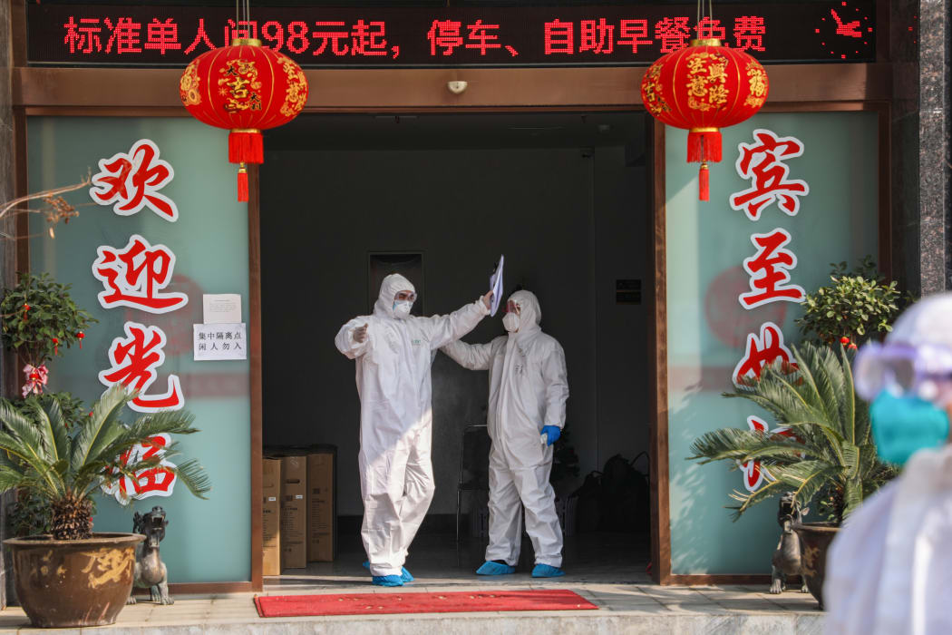 Medical staff member (left) being disinfected by a colleague before leaving a quarantine zone converted from a hotel in Wuhan, 3 February 2020.