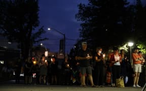 People hold lit candles during a vigil in honour of the victims of a stabbing spree that killed ten people in Saskatchewan, Canada.