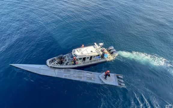 This handout picture released by the Colombian National Navy shows Navy members intercepting and arresting a semi-submersible carrying cocaine hydrochloride in the pacific coast of Colombia on March 13, 2023. The Colombian Navy intercepted a semi-submersible of approximately 15 meters long carrying 2,643 kilograms of cocaine hydrochloride which was destined for distribution in Central America. (Photo by Colombian National Navy / AFP) / RESTRICTED TO EDITORIAL USE - MANDATORY CREDIT "AFP PHOTO /  COLOMBIAN NATIONAL NAVY" - NO MARKETING NO ADVERTISING CAMPAIGNS - DISTRIBUTED AS A SERVICE TO CLIENTS