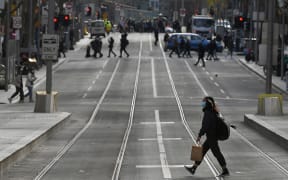 A shopper crosses the street in the central business district in Melbourne on July 7, 2021