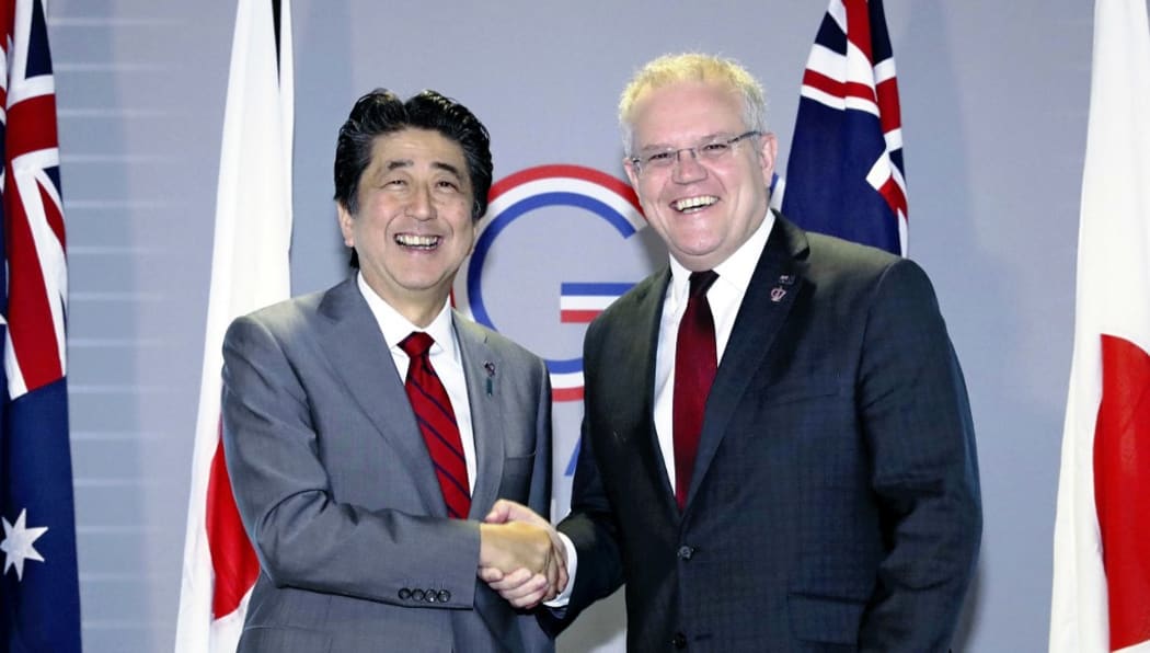 Australias Prime Minister Scott Morrison shakes hands with Japan's counterpart Shinzo Abe ahead of their summit meeting during the G7 summit meeting in Biarritz.