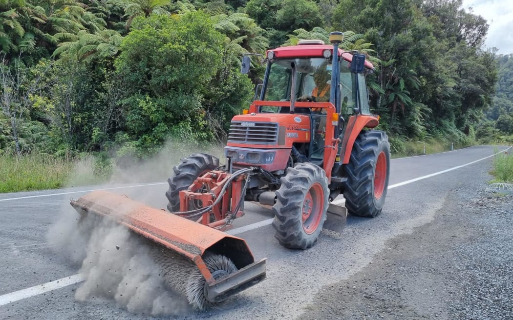 A contractor puts the finishing touches to new seal on SH43 at Tangarakau Gorge.