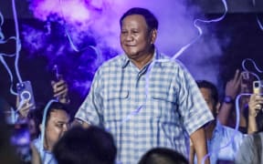 Presidential candidate and Indonesia's Defence Minister Prabowo Subianto, centre. dances on the stage during a gathering with supporters after polls closed in the country’s presidential and legislative elections in Jakarta on 14 February 2024.